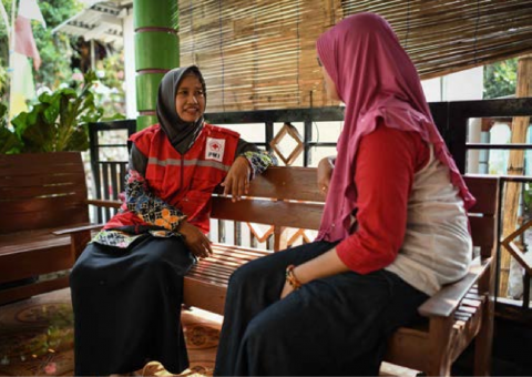 Two women, one a PMI volunteer, sitting and talking