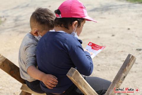 Two boys reading a COVID flyer. Romania.